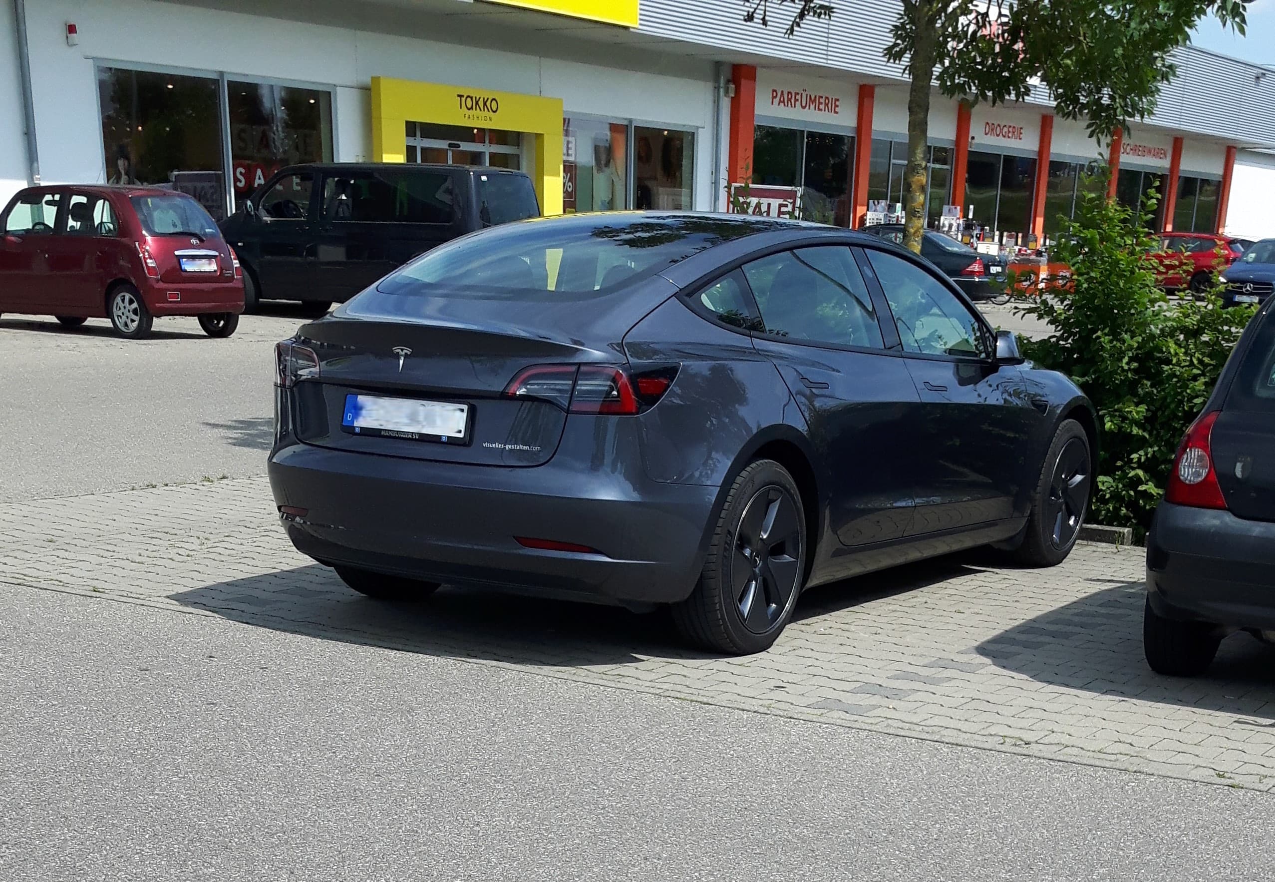 A dark grey Tesla Model 3 parked outdoors, representing the company at the centre of the investor debate